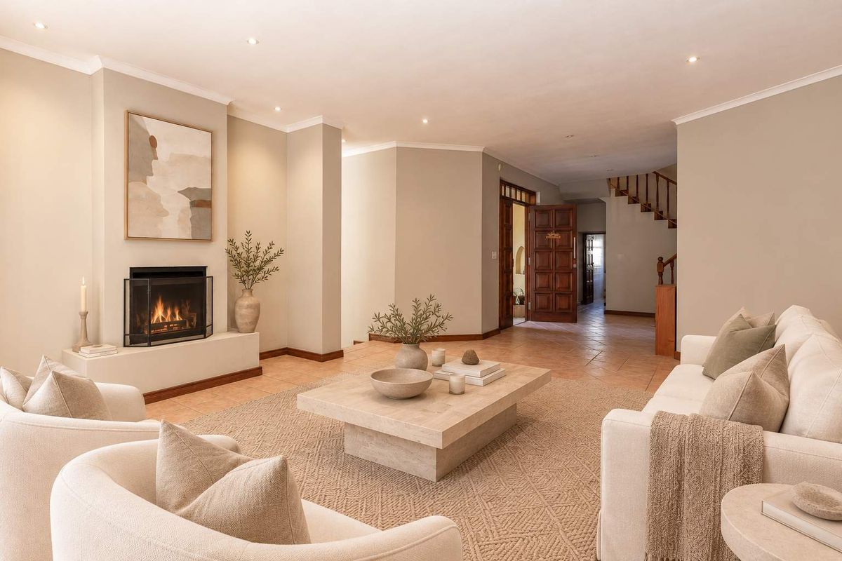 Spacious living room featuring a built-in fireplace, neutral tiled flooring, recessed lighting, and an open-plan layout leading to a staircase and hallway.