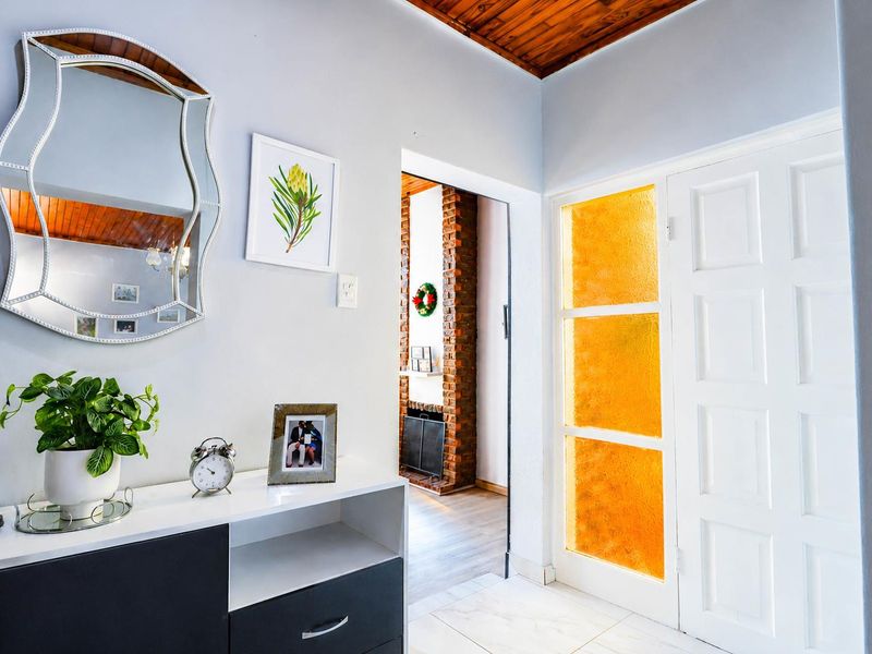 Welcoming entrance hall featuring a timber ceiling, tiled flooring, and a classic panelled door with decorative glass inserts.