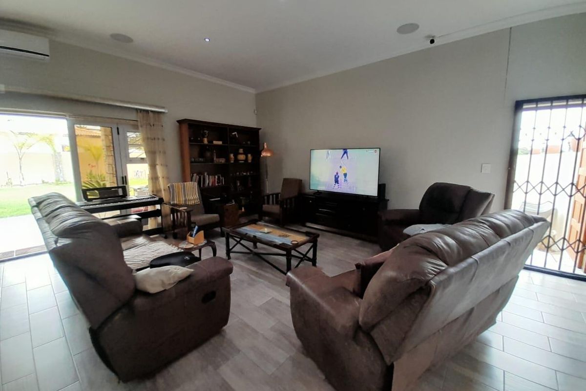Spacious living room featuring tiled flooring, recessed ceiling lighting, and sliding glass doors providing direct access to the outdoor area.