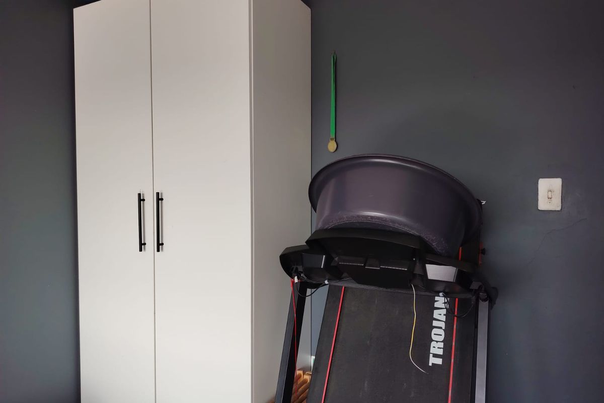 A bedroom featuring a white built-in wardrobe against a dark grey wall.