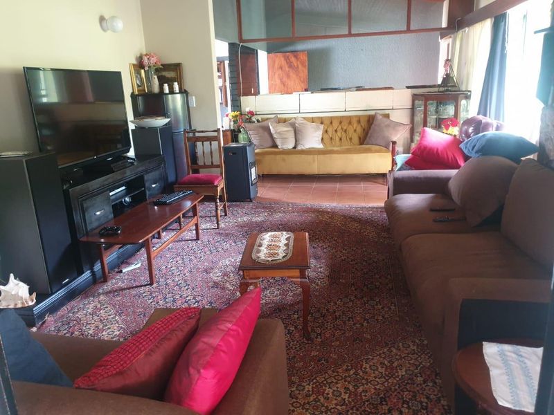 A spacious living room featuring tiled flooring and a partial room divider, offering a comfortable and functional layout for relaxation.