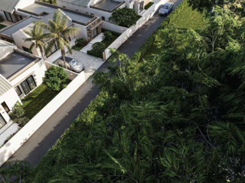 An aerial view of a modern residential estate featuring paved driveways, landscaped gardens, and contemporary homes with metal roofing.