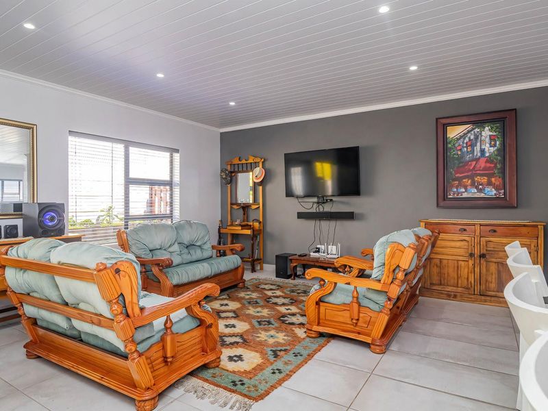 Spacious open-plan living area featuring tiled flooring, recessed downlights, and a modern tongue and groove ceiling finish.