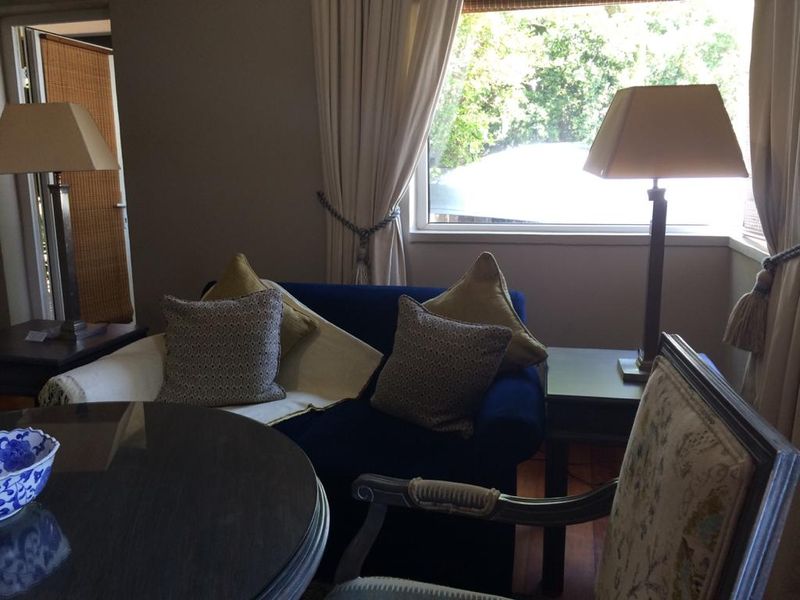 A cozy living room area featuring a bay window with natural light and hardwood flooring.