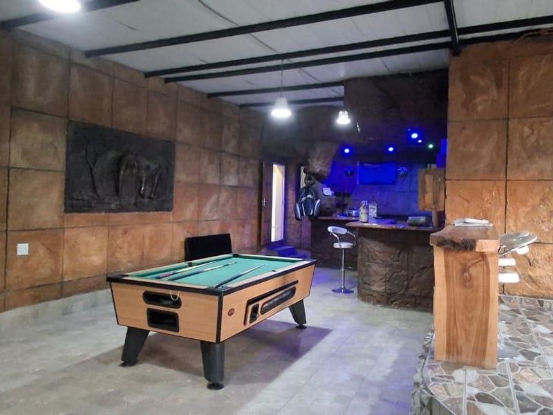 A dedicated entertainment bar area featuring stone-textured wall cladding, a built-in bar counter, and a raised platform with tiled flooring.