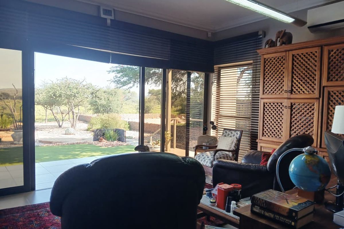 A living room featuring large sliding glass doors that provide seamless access to an outdoor patio and garden area.