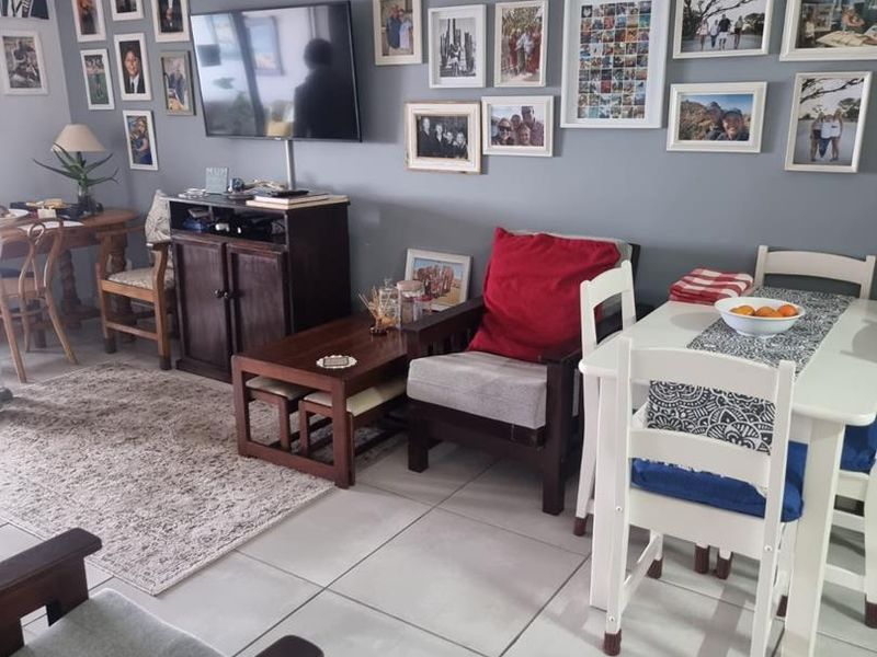 Open plan living and dining area featuring tiled flooring and a wall-mounted television, providing a functional space for daily living.