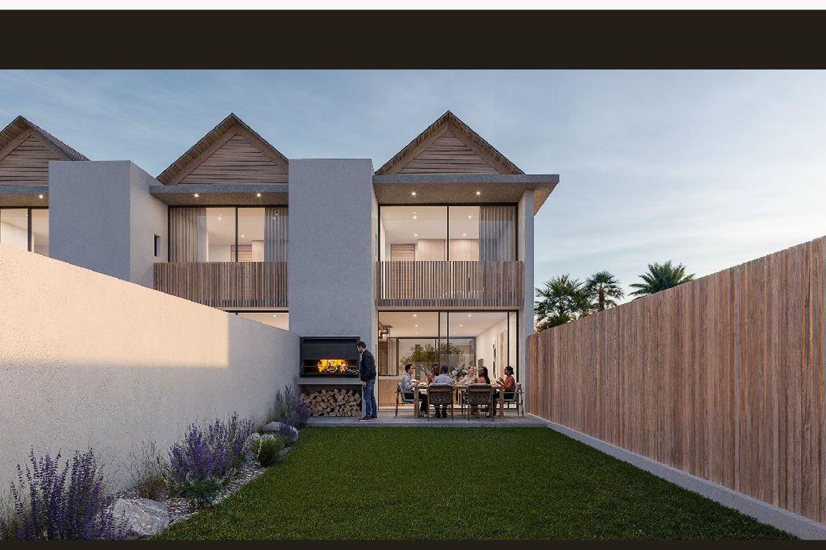Rear view of a modern townhouse featuring a private garden, paved patio area with a built-in braai, and timber-clad balcony details.