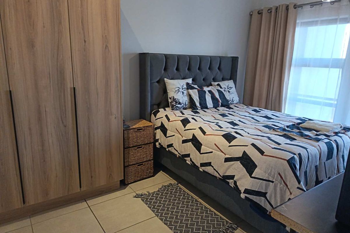 A well-maintained bedroom featuring built-in wooden cabinetry and tiled flooring, offering a clean and functional living space.