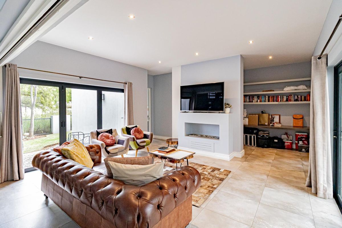 Spacious living room featuring a built-in fireplace, recessed lighting, tiled flooring, and large sliding glass doors providing seamless access to the outdoor area.