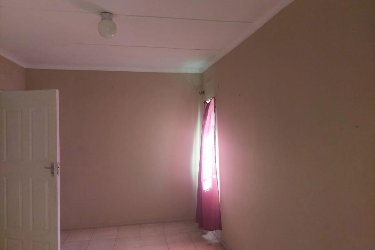 An empty bedroom featuring tiled flooring and neutral wall finishes, offering a blank canvas for potential interior design updates.