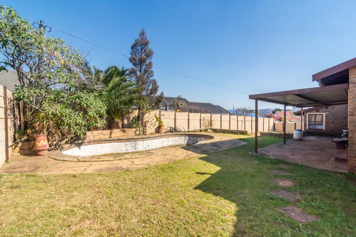 Rear garden area featuring a swimming pool, covered patio space, and perimeter walling, offering potential for outdoor renovation and landscaping.
