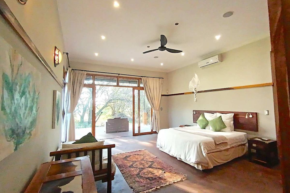 Spacious bedroom featuring concrete floors, recessed lighting, a ceiling fan, and sliding glass doors that open onto a private outdoor patio area.