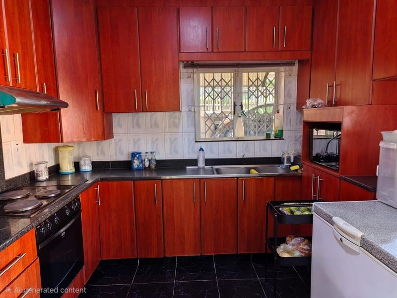 A functional kitchen featuring dark wood-look cabinetry, granite-style countertops, a built-in oven and hob, and a window with security bars.