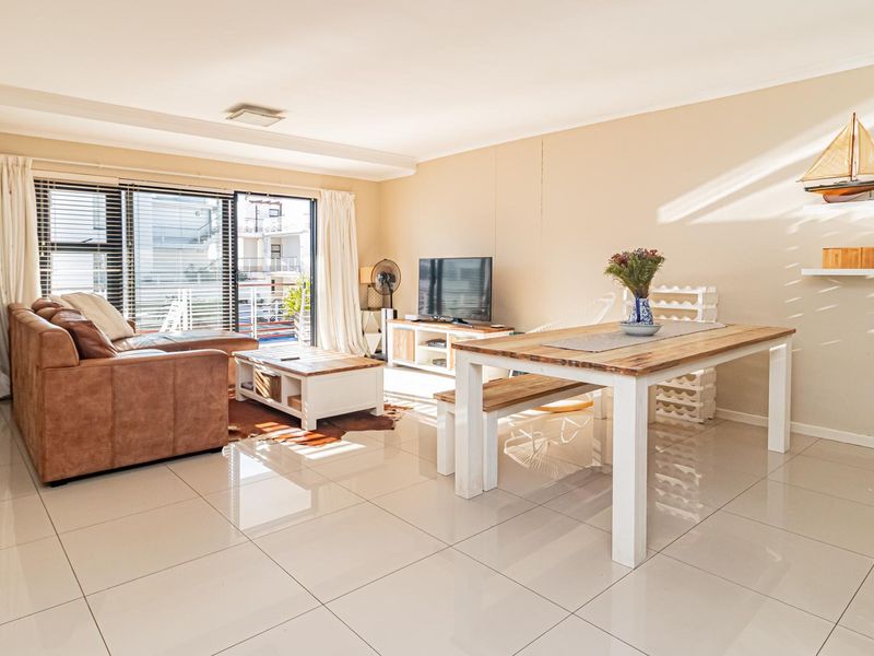 Bright open-plan living and dining area featuring large sliding glass doors that provide natural light and access to the outdoor space.
