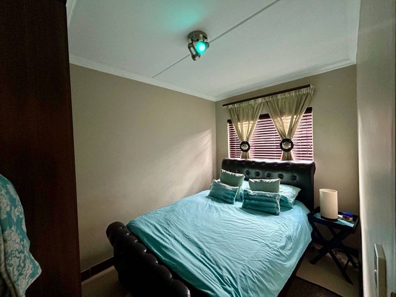 A compact bedroom featuring a coved ceiling, venetian blinds, and a ceiling-mounted spotlight fixture.