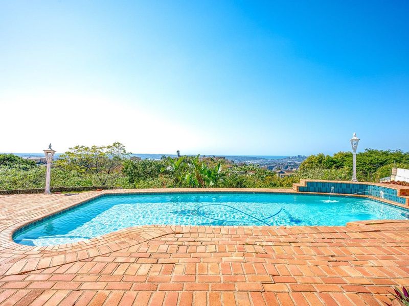 Outdoor swimming pool area featuring brick paving, a built-in water feature, and expansive elevated views of the surrounding landscape.