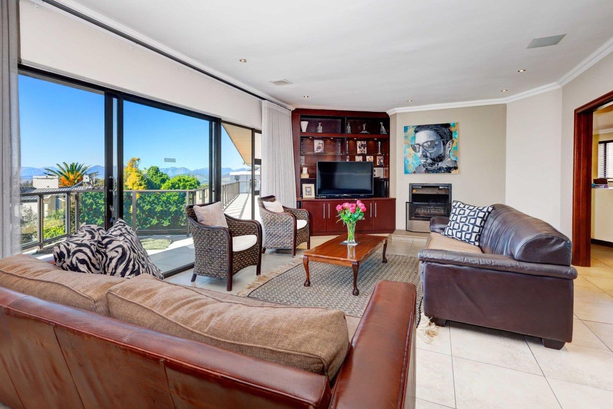 Spacious living room featuring built-in cabinetry, a fireplace, and large sliding glass doors that open to an outdoor balcony with scenic views.