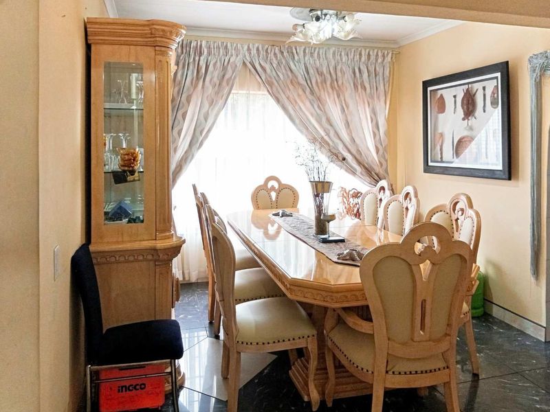 A dining room featuring tiled flooring and a central ceiling light fixture, providing a functional space for family meals.