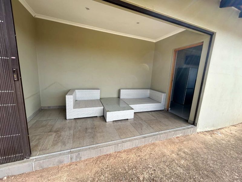 A covered patio area featuring tiled flooring and recessed lighting, providing a seamless transition to the interior living space.