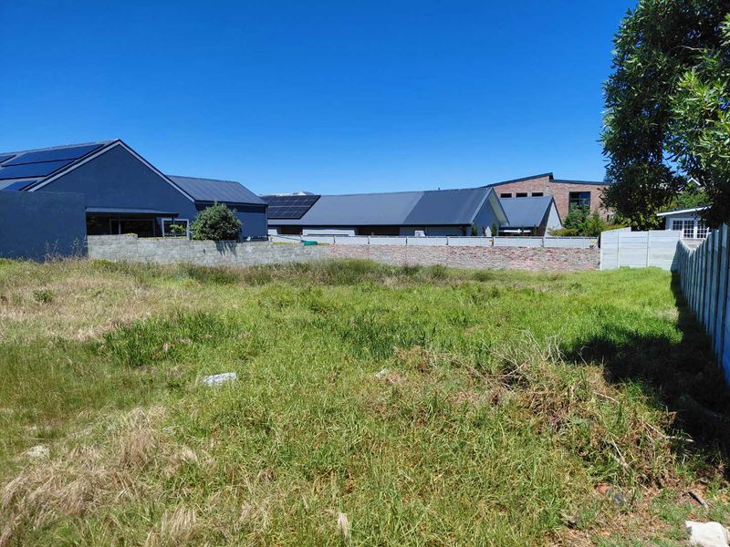 A vacant residential plot featuring established boundary walls and precast concrete fencing, ready for development.