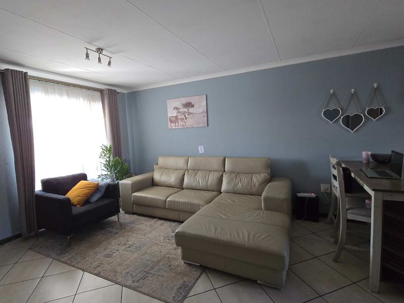 A comfortable living room featuring tiled flooring and neutral wall tones, providing a functional and inviting space for relaxation.