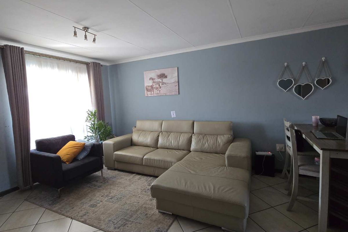 A comfortable living room featuring tiled flooring and neutral wall tones, providing a functional and inviting space for relaxation.