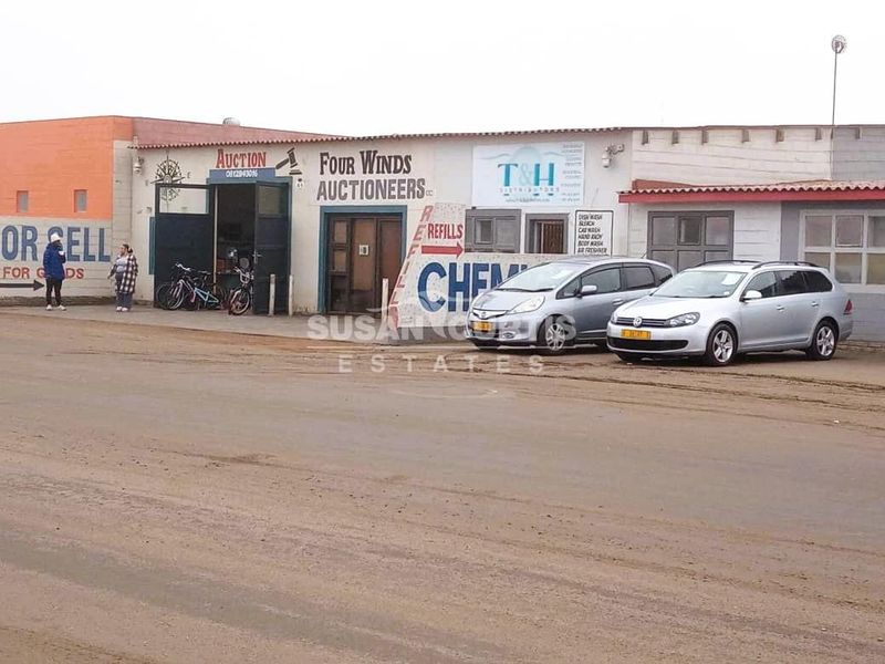 Front elevation of an industrial commercial property featuring multiple business entrances, signage, and roller shutter access doors.