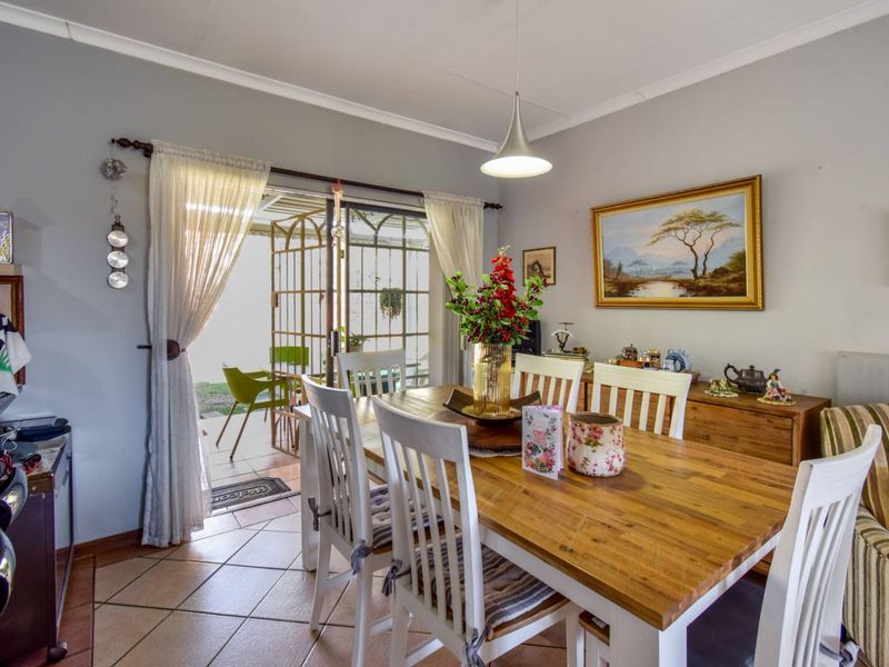 A bright dining area featuring tiled flooring, a pendant light, and a sliding glass door providing direct access to the outdoor patio.