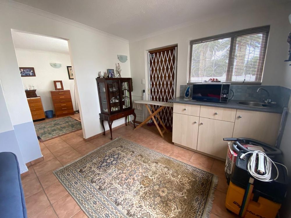 Bedroom two with a kitchenette and a small lounge. Door leading out to the side of the house
