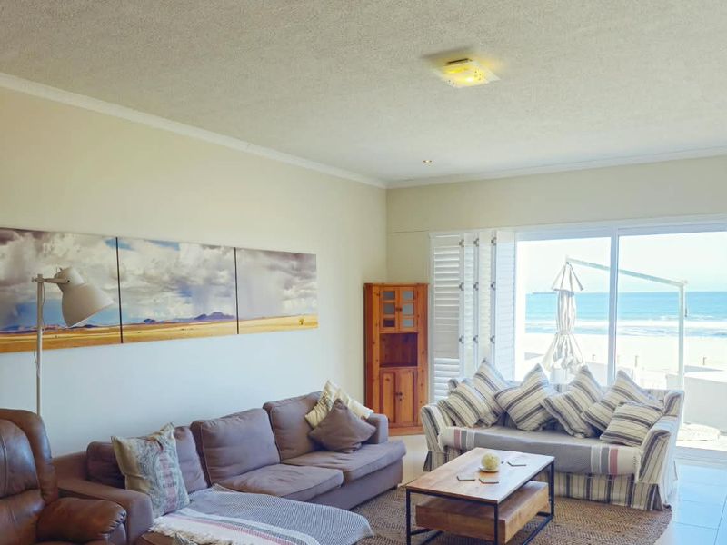 Spacious living room featuring large sliding glass doors that provide direct access to the patio and offer expansive ocean views.
