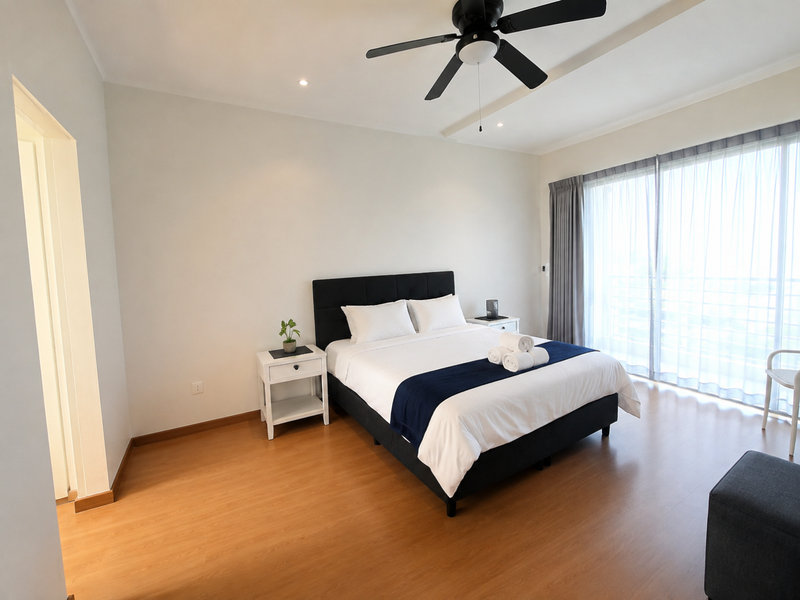 A bright and spacious bedroom featuring laminate flooring, a ceiling fan, and large sliding glass doors that provide ample natural light.