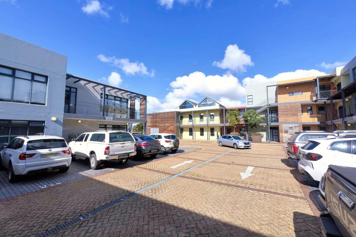 A view of the office park courtyard featuring paved parking areas and modern multi-story commercial building facades.