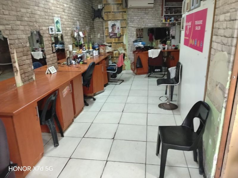 A commercial salon space featuring built-in vanity stations, wall-mounted mirrors, tiled flooring, and air conditioning, suitable for retail or beauty service operations.