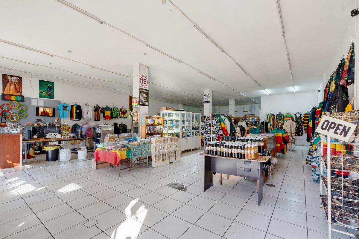 Open-plan retail space featuring ceramic tiled flooring, structural support columns, and overhead fluorescent lighting, suitable for various commercial display layouts.