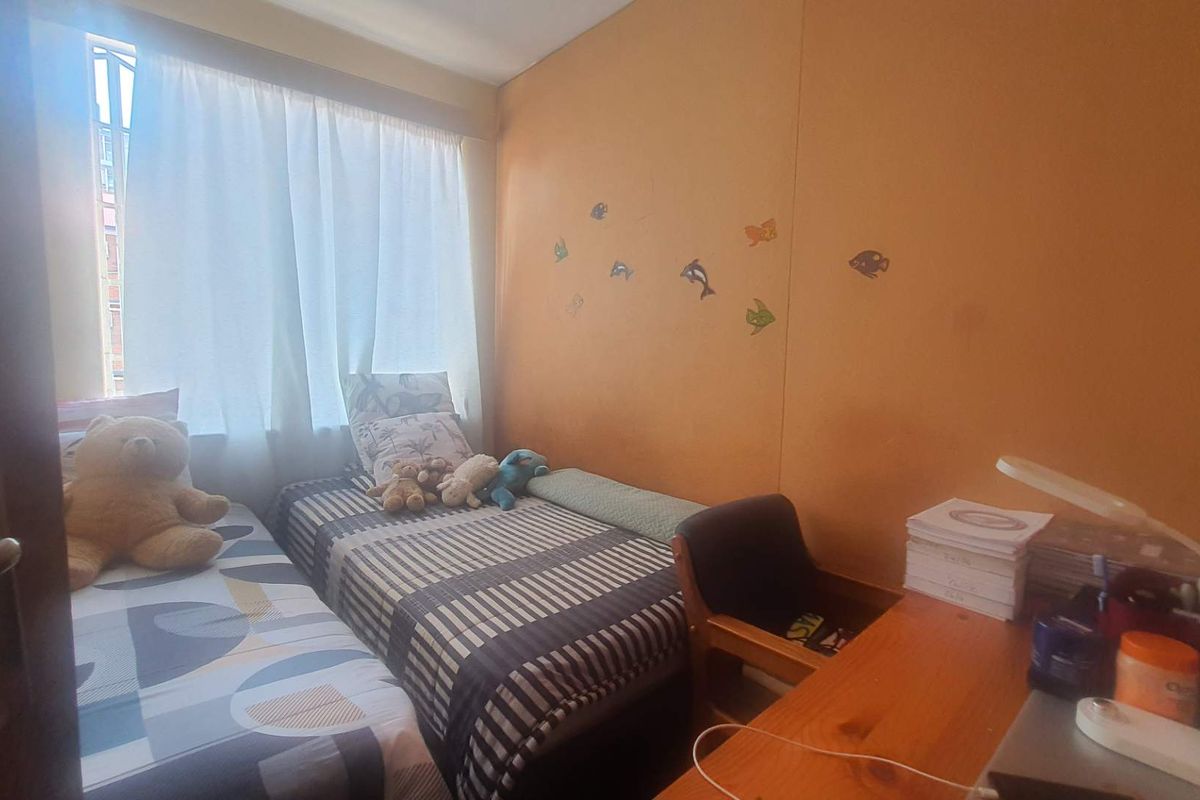 A compact bedroom featuring a window with natural light, suitable for a single or twin bed setup.