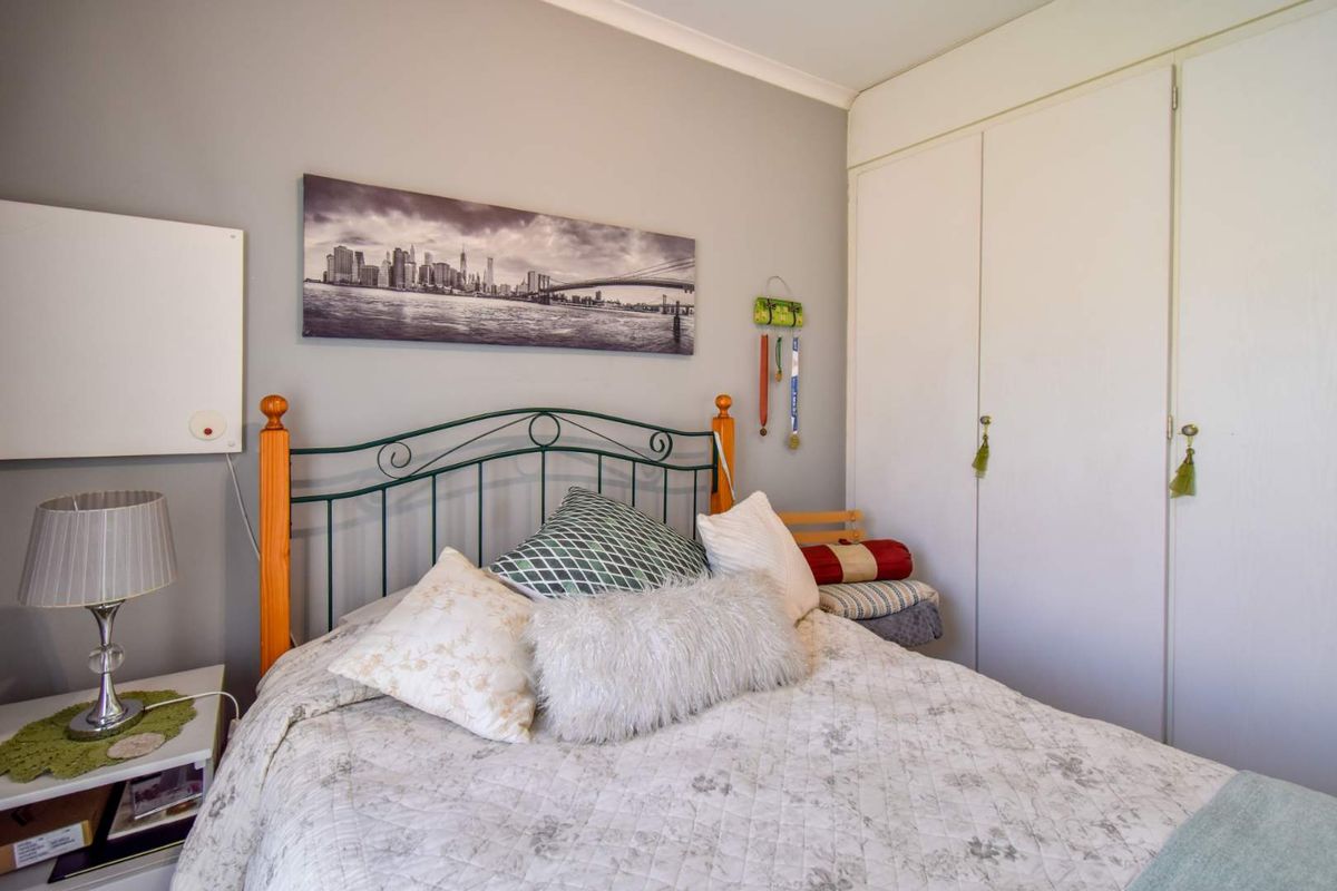 A bedroom featuring neutral wall paint, coving, and a built-in wardrobe with white doors.