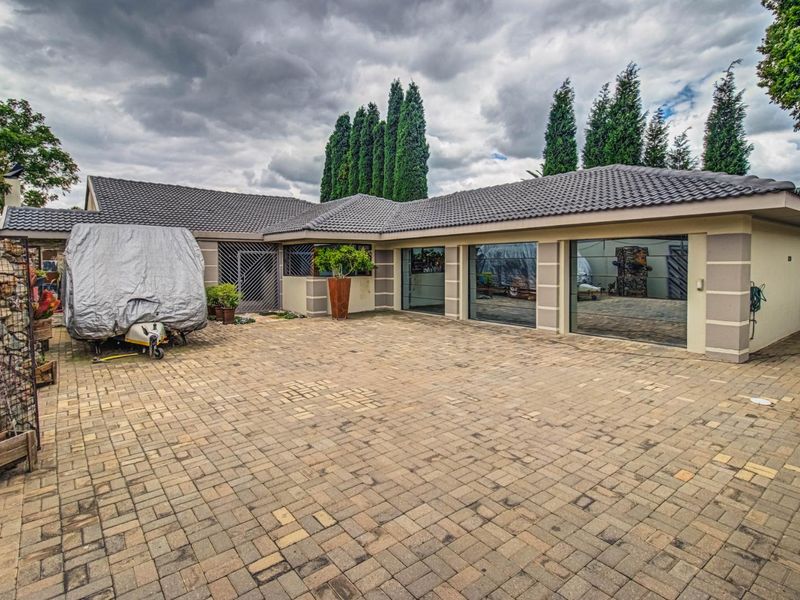 Spacious paved driveway leading to a multi-car garage with a tiled roof and modern exterior finishes.