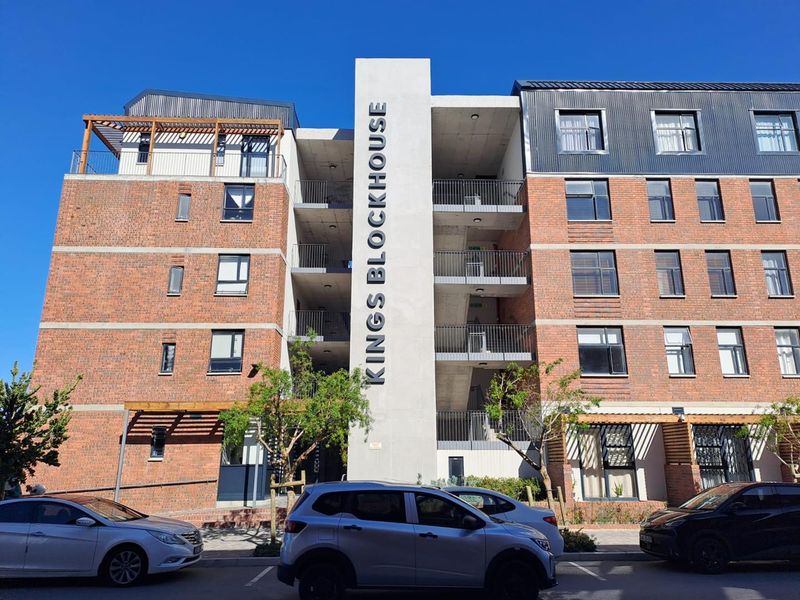 Front elevation of Kings Blockhouse apartment building featuring a modern brick and concrete facade with integrated stairwell and timber pergola details.