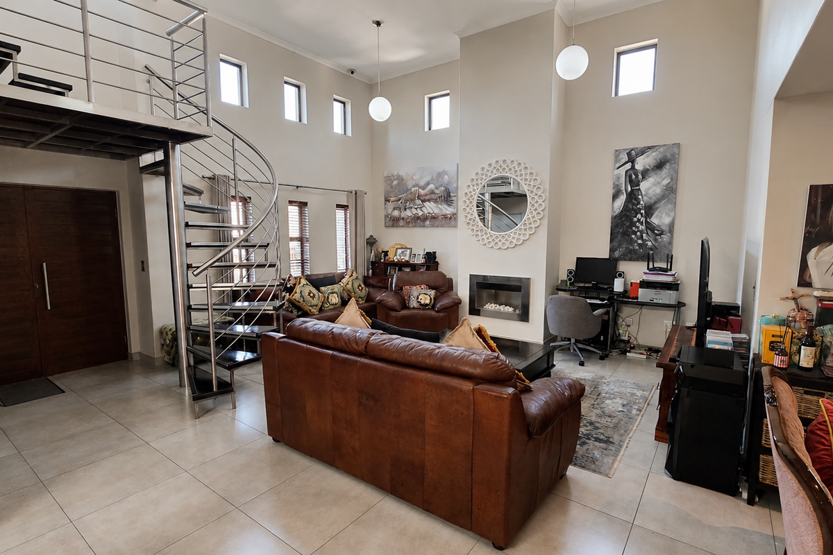 Spacious double-volume living room featuring a modern spiral staircase, built-in fireplace, and large windows providing ample natural light.
