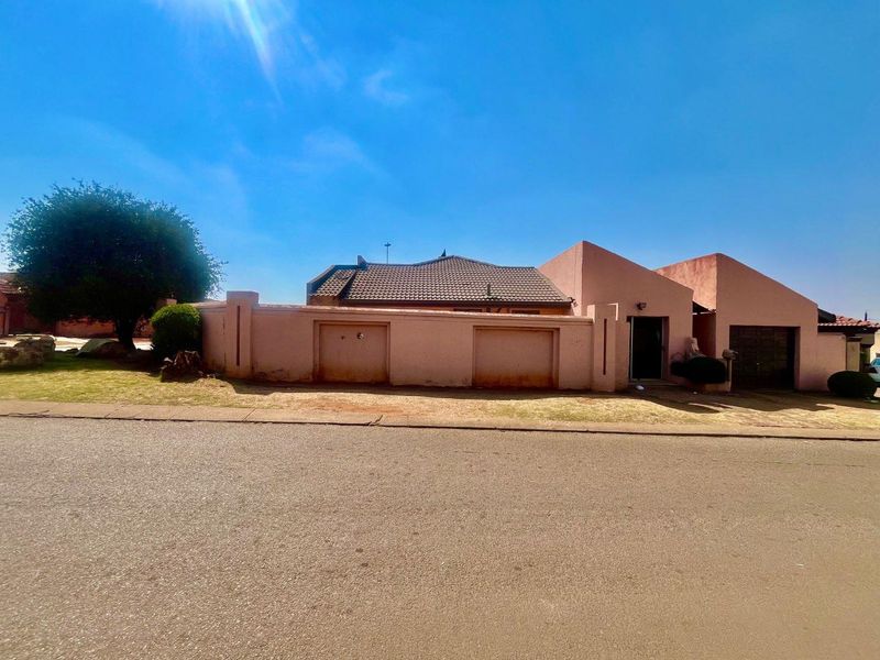 Front exterior view of a single-story house featuring a perimeter wall, tiled roof, and garage access from the street.