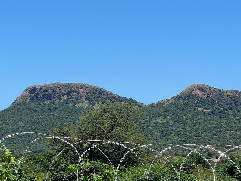 A scenic view of the surrounding mountain landscape, captured from the property boundary.
