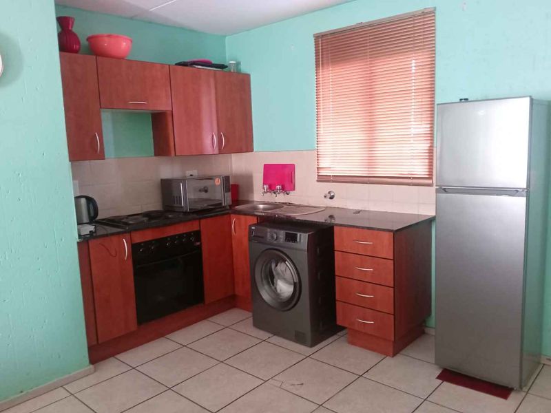 A functional kitchen featuring laminate cabinetry, granite countertops, a built-in oven, and tiled flooring, offering a practical layout for daily use.