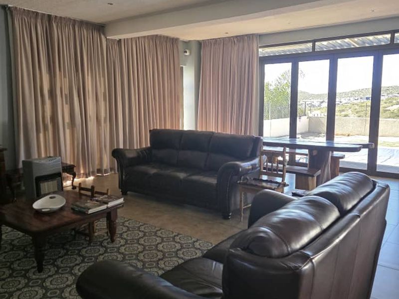 Spacious living room featuring tiled flooring, recessed lighting, and large sliding glass doors that provide access to the outdoor area.