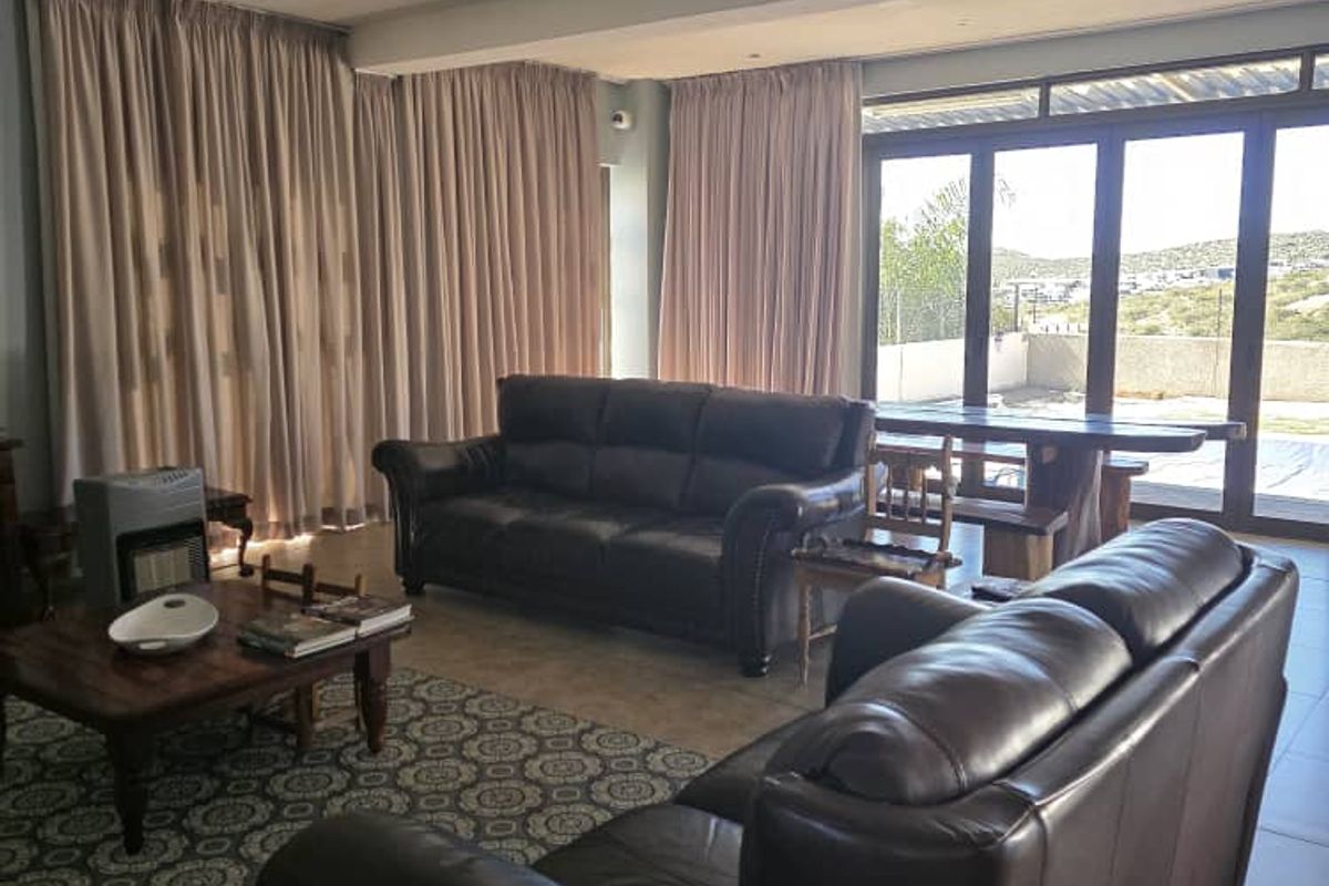 Spacious living room featuring tiled flooring, recessed lighting, and large sliding glass doors that provide access to the outdoor area.