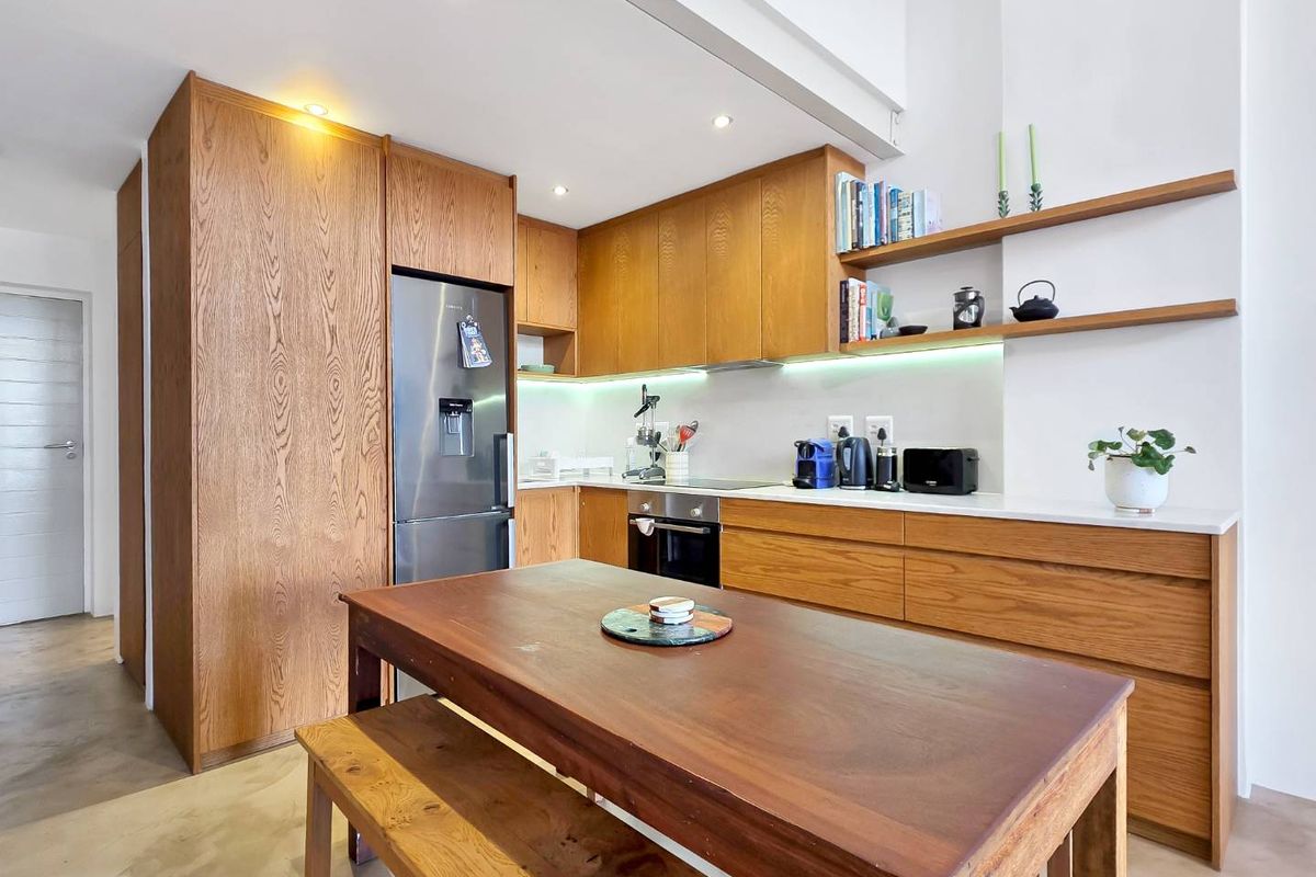 Modern kitchen featuring high-quality wood cabinetry, integrated appliances, stone countertops, and sleek under-cabinet lighting, creating a warm and functional culinary space.