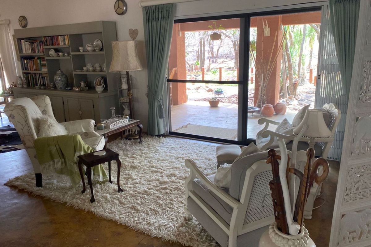 A comfortable living room featuring polished concrete floors and large sliding glass doors that open onto a covered patio area.