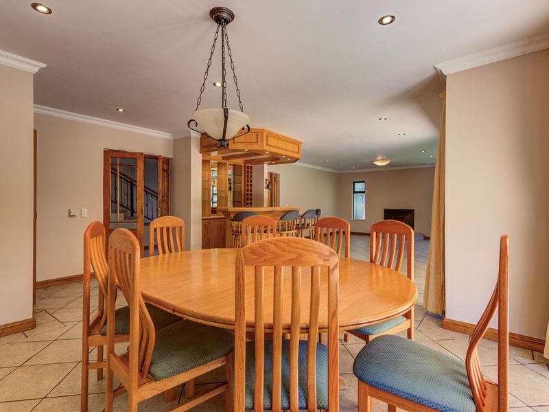 Spacious open-plan dining area featuring tiled flooring, recessed lighting, and a built-in bar, creating a versatile space for entertaining.