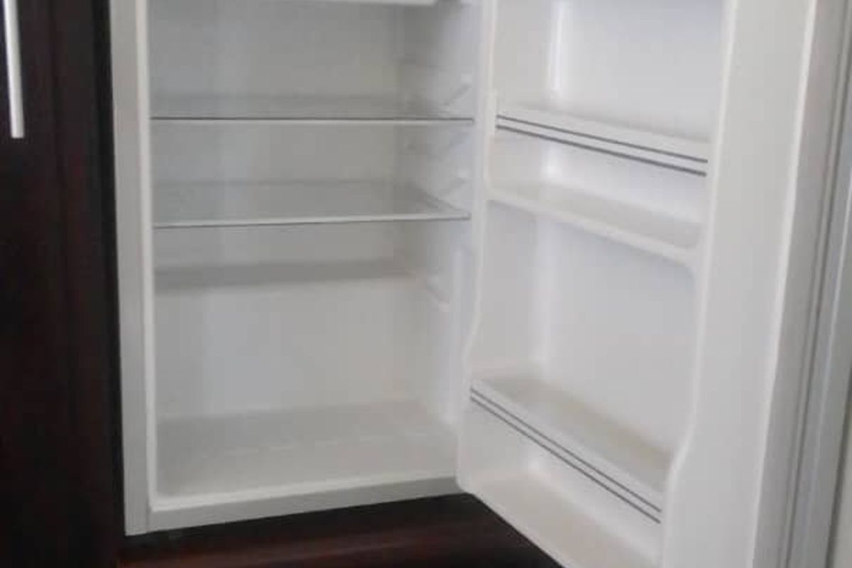 A close-up view of a built-in kitchen cabinet unit featuring an integrated refrigerator with dark wood finish cabinetry.