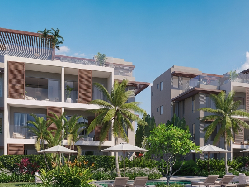 Modern penthouse apartment complex featuring tiered balconies, timber louvre shutters, glass balustrades, and a shared swimming pool area set within landscaped tropical gardens.